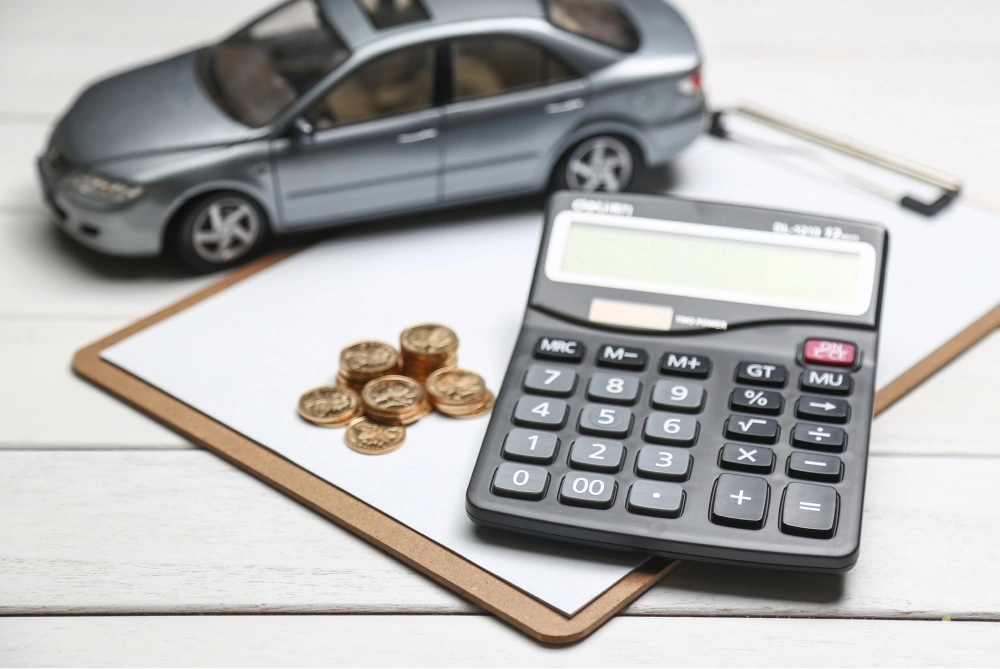 car-model-calculator-and-coins-on-white-table 1.jpg